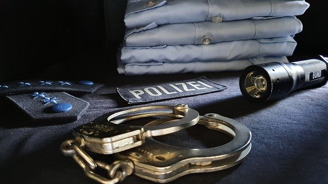 photo of handcuffs, flashlight and police uniform