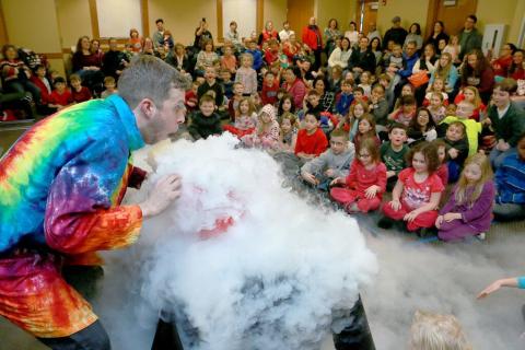 Performer looking at vapor cloud from dry ice
