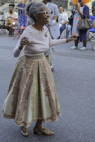 woman in long decorative skirt dancing in the street