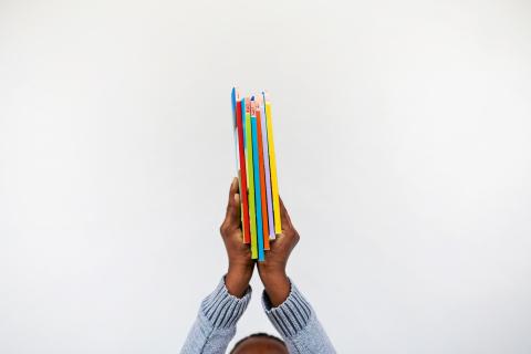 child's hands holding books overhead