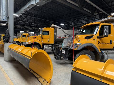 yellow snow plows parked in a large warehouse