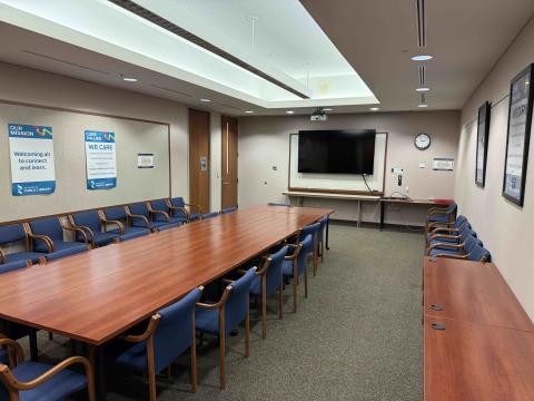 Meeting room with tabels, chairs, and a large screen