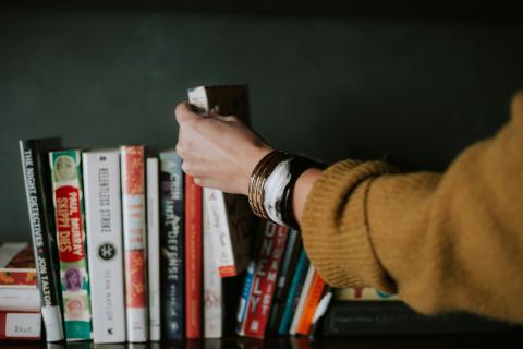 hand picking a book off a shelf