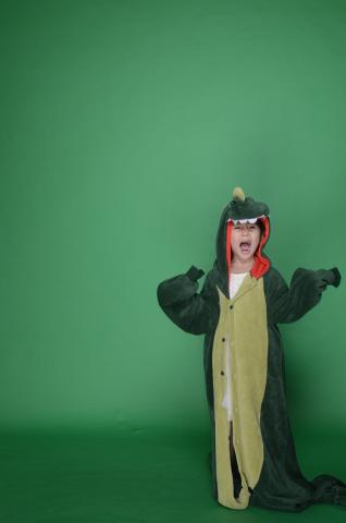 child in green dinosaur costume