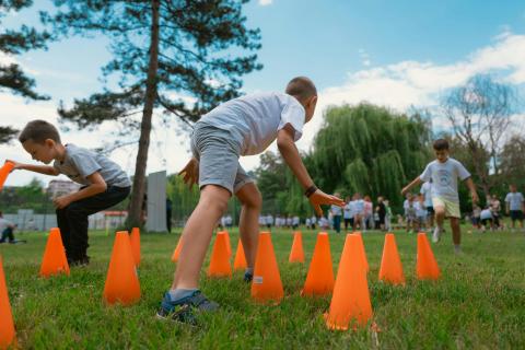 kids outside running through cone obstacles