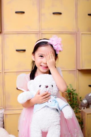 child holding stuffed bear