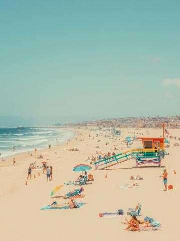 image of beach with umbrellas, lifeguard stand, sand, ocean and sky