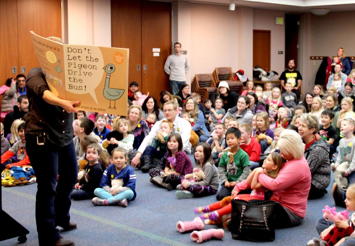 A large group of parents and children listening to the chosen story