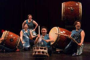 several people ready to play large drums