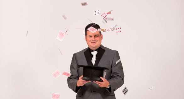 Magician with playing cards flying around him