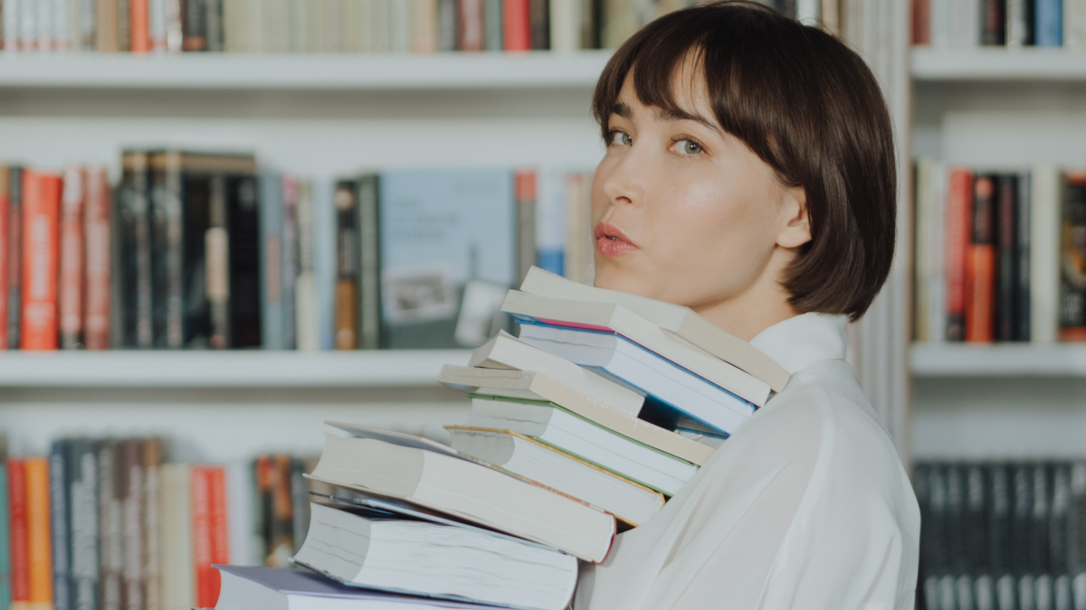 woman holding a stack of books