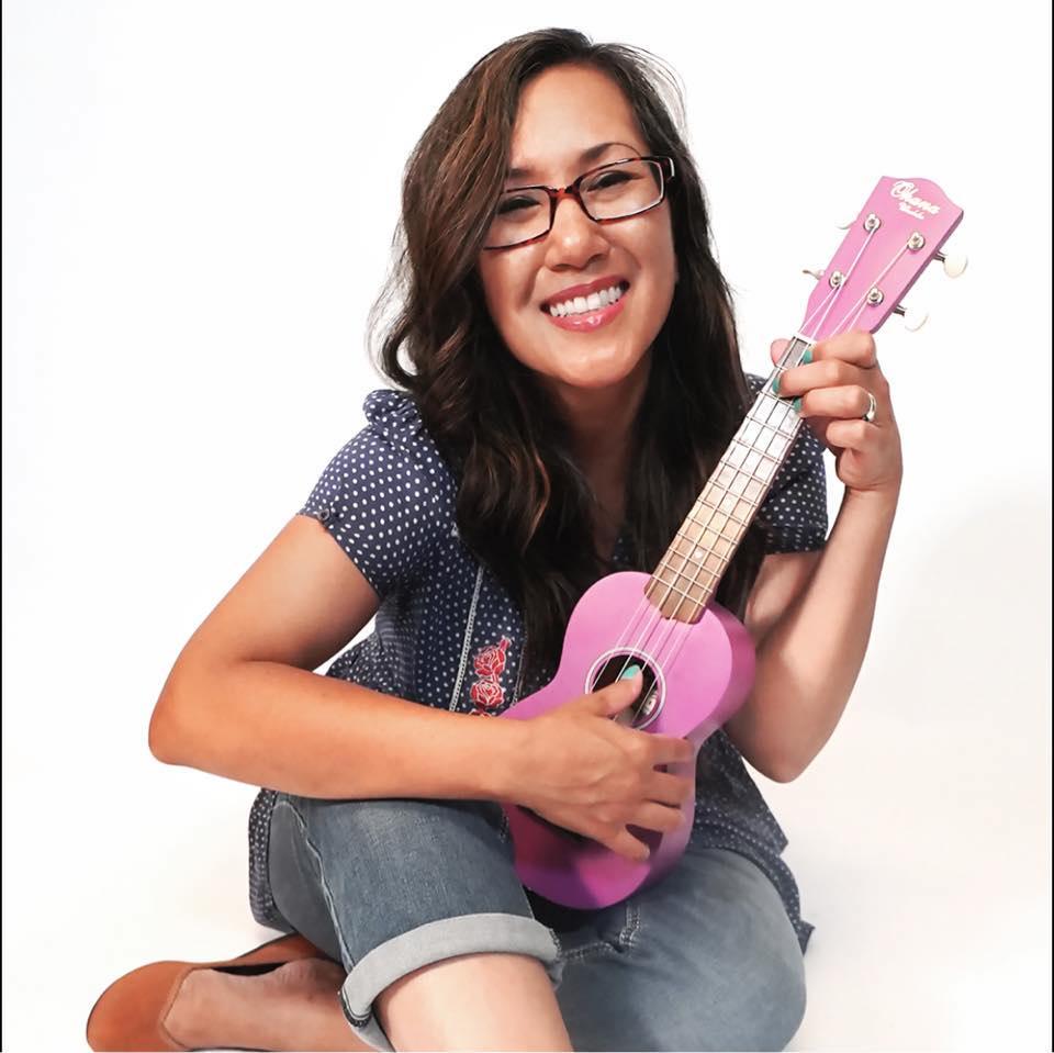 woman holding pink ukulele