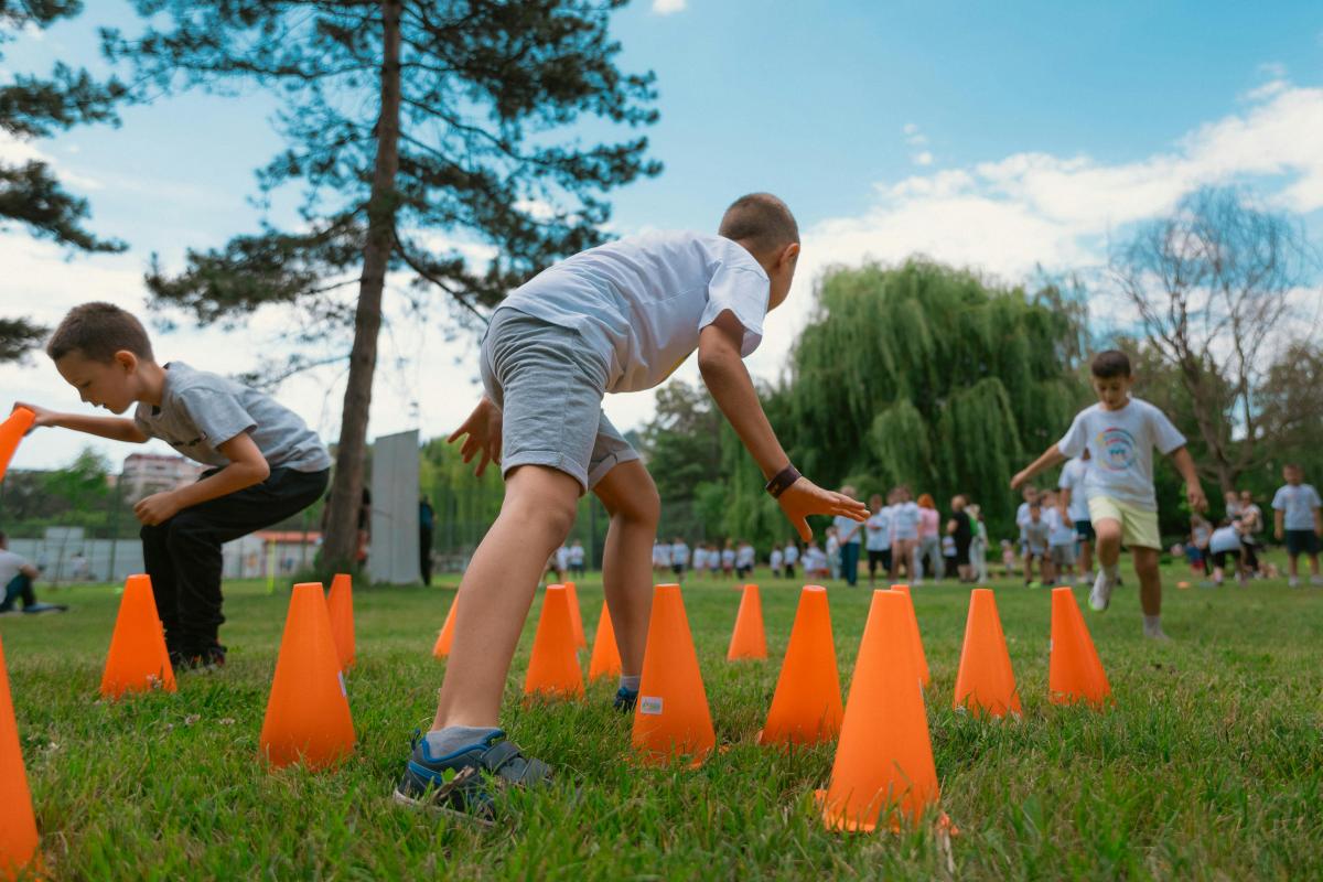 kids outside running through cone obstacles
