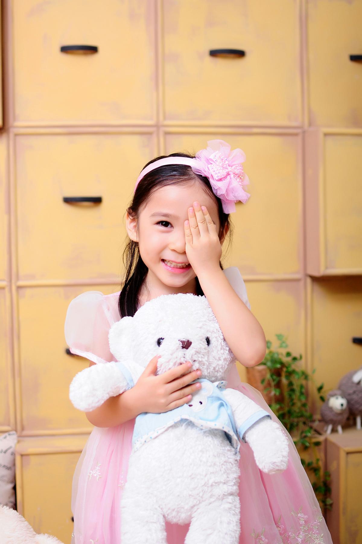 child holding stuffed bear